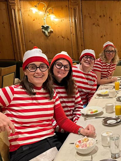 A group of Denplan dentists dressed in Where's Wally fancy dress sat at a table eating breakfast