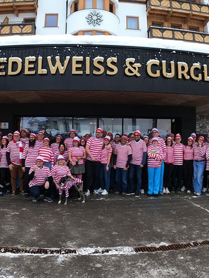 A large group of Denplan dentists wearing Where's Wally fancy dress stood outside the Edelweiss & Gurgle hotel