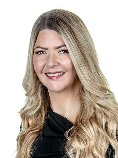 Smiling woman with long, wavy blonde hair and a black top
