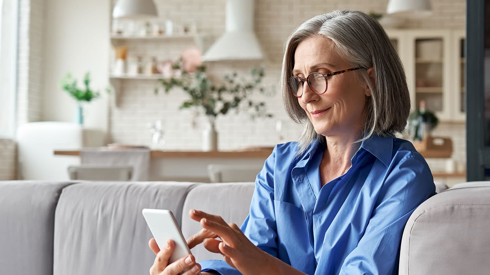 Lady using mobile phone on sofa