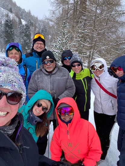 A group of Denplan dentists wearing ski goggles and clothes on a snowy hillside