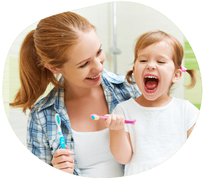 Mother helping toddler brush teeth