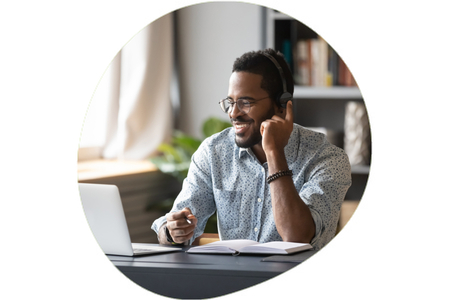 Man wearing headset and smiling at laptop