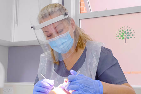 Dentist at work wearing full PPE