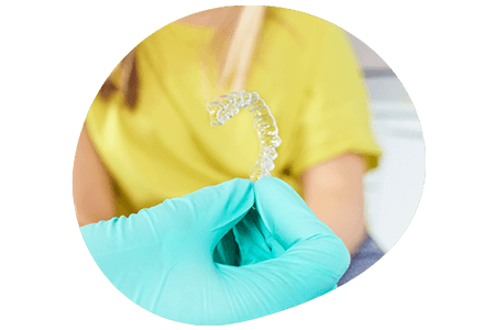 Dentist holding a retainer showing a patient