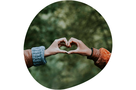 Two people making a heart shape with their hands