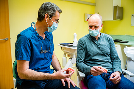 Dentist Dr Hernan Morillo talking to a patient