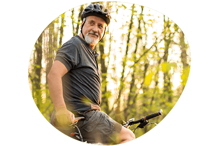 Man smiling on mountain bike in the forest
