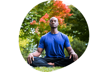 Man meditating on mat outside