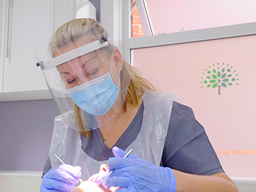 Dentist wearing PPE working on a patient