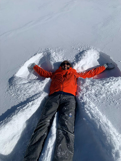A Denplan dentist lying in the snow making a snow angel